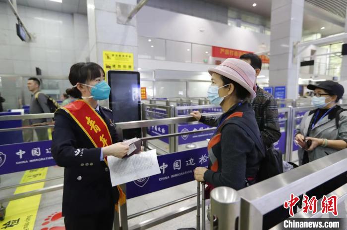 图为民警对首批出境旅行团进行证件查验。　周日 摄