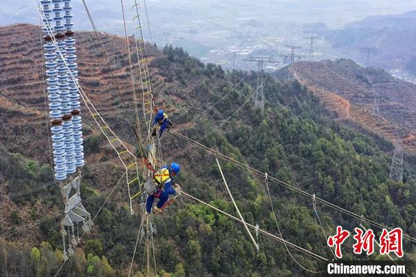 图为施工人员进行索桥跨越网的搭设工作。　邹建华 摄