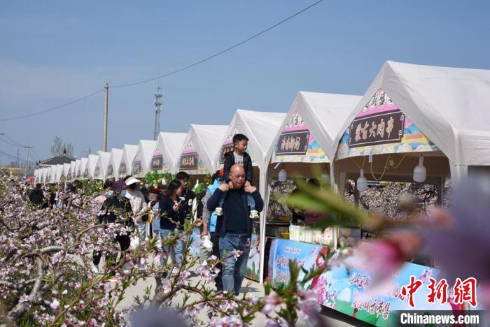 周边十里八乡的民众共赴西堡村桃园集市。　 朱志庚 摄