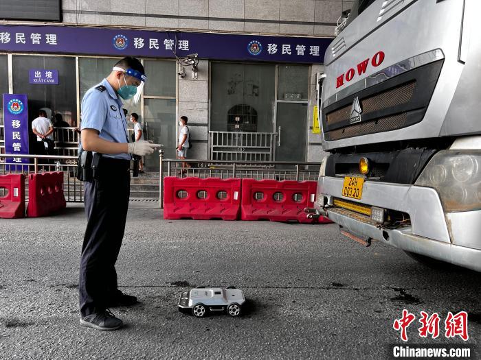 图为民警使用车底检查机器人对货运车辆进行检查。　河口边检站供图