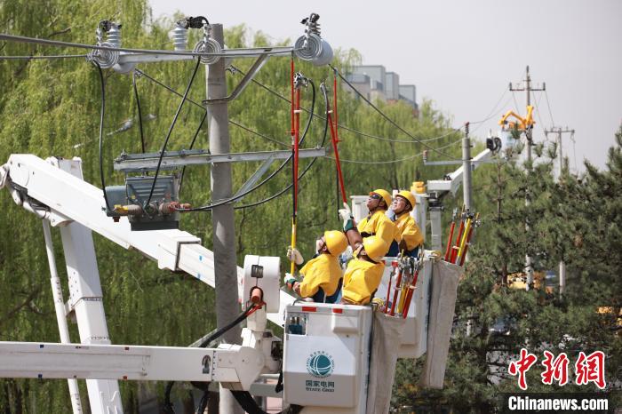 13日，国网北京电力带电作业人员在海淀区西北旺永丰地区进行配网带电综合检修作业。　张笑谭　摄