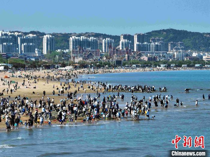 五一假期首日，山东日照阳光海岸迎来第一波游客，漫步海滩，尽享假日时光。　赵洪生 摄